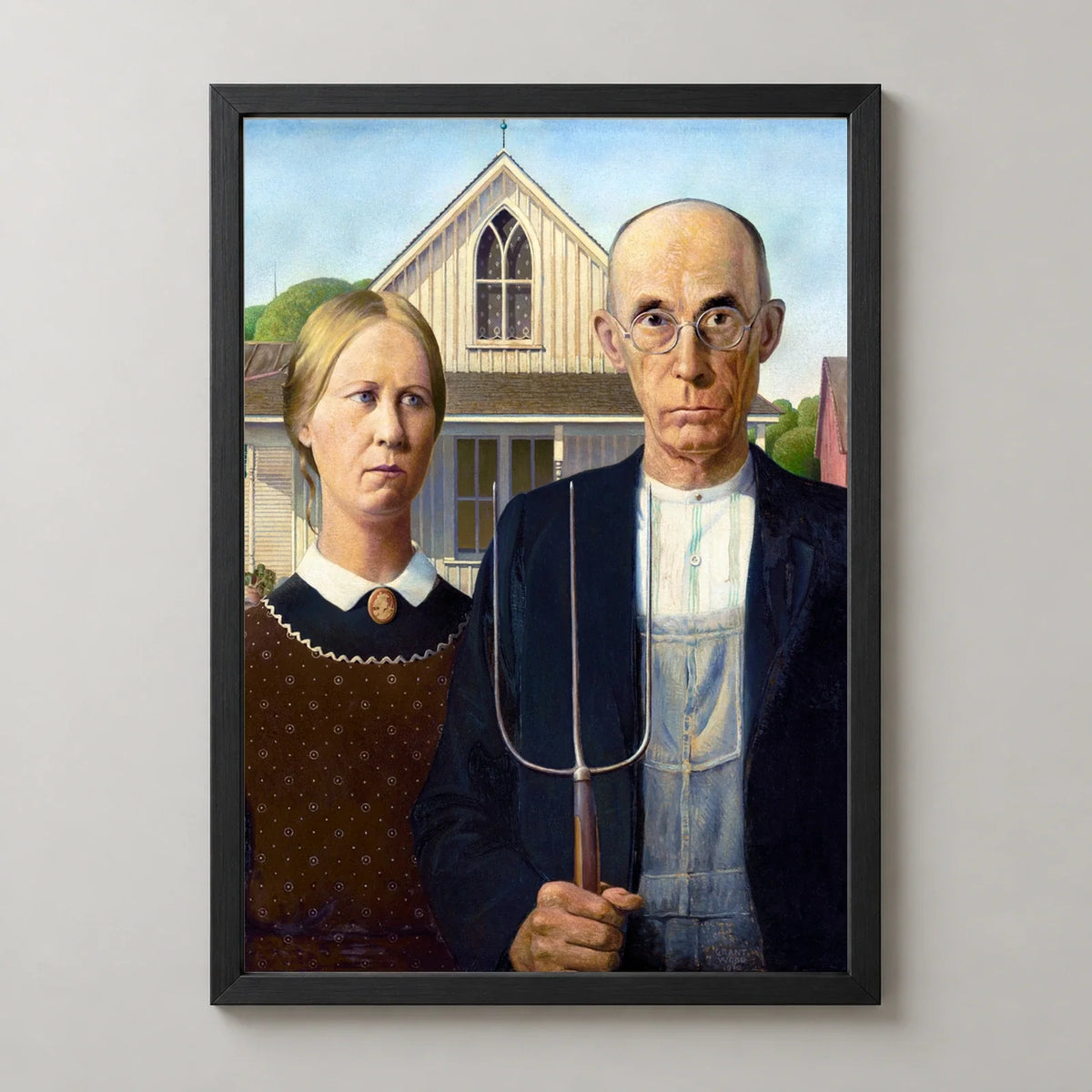 American Gothic Art Print by Grant Wood in a black frame, front view