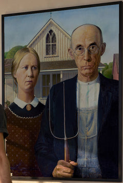 American Gothic Art Print by Grant Wood in a black frame; close-up of the framed artwork.