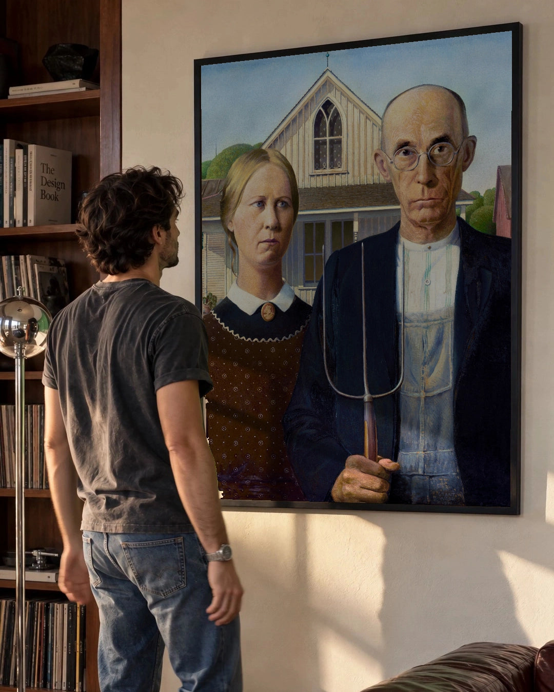 American Gothic Art Print by Grant Wood in a black frame; styled man setting.