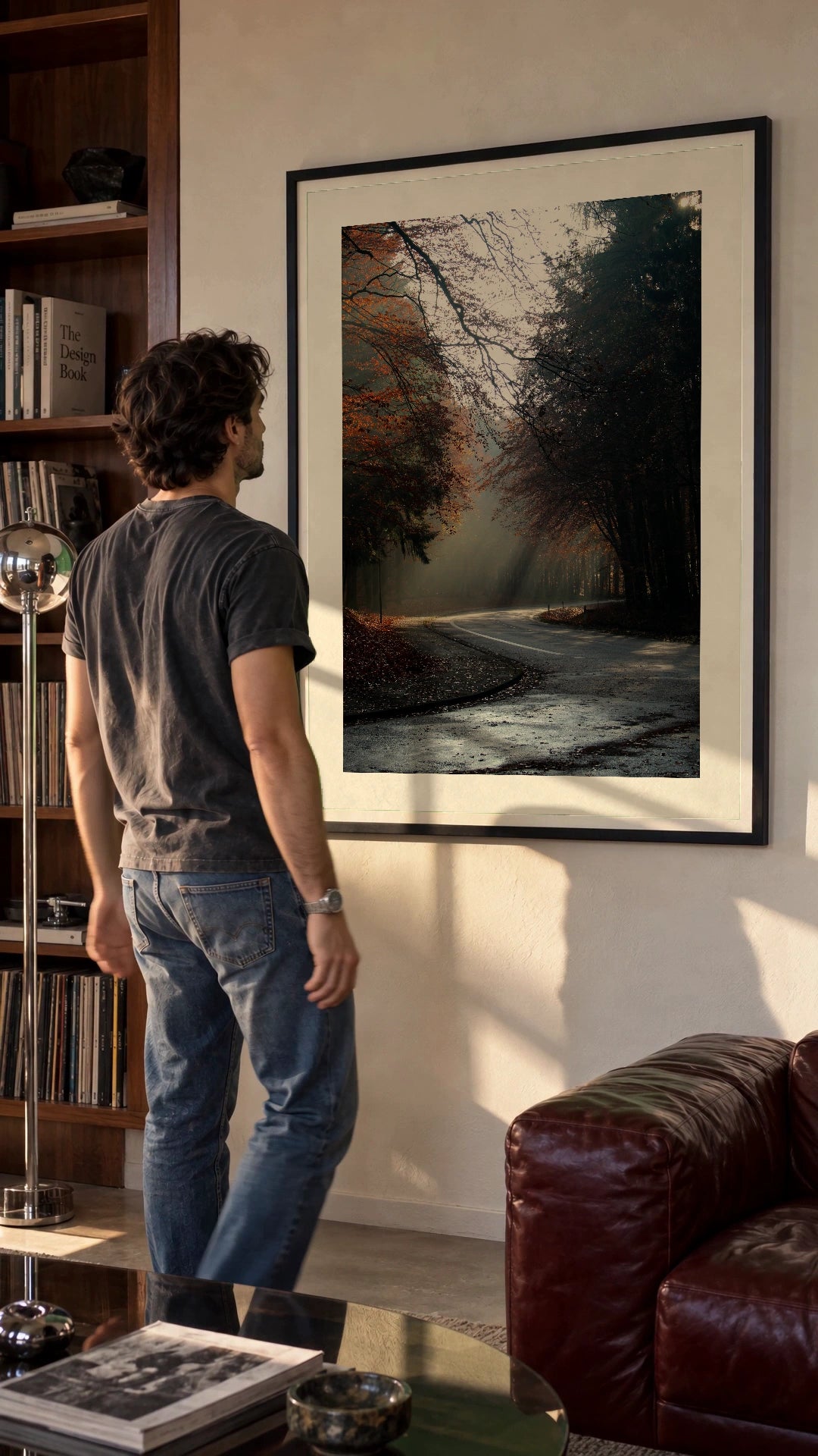 Autumn Forest in a black frame being hung on a wall; styled scene