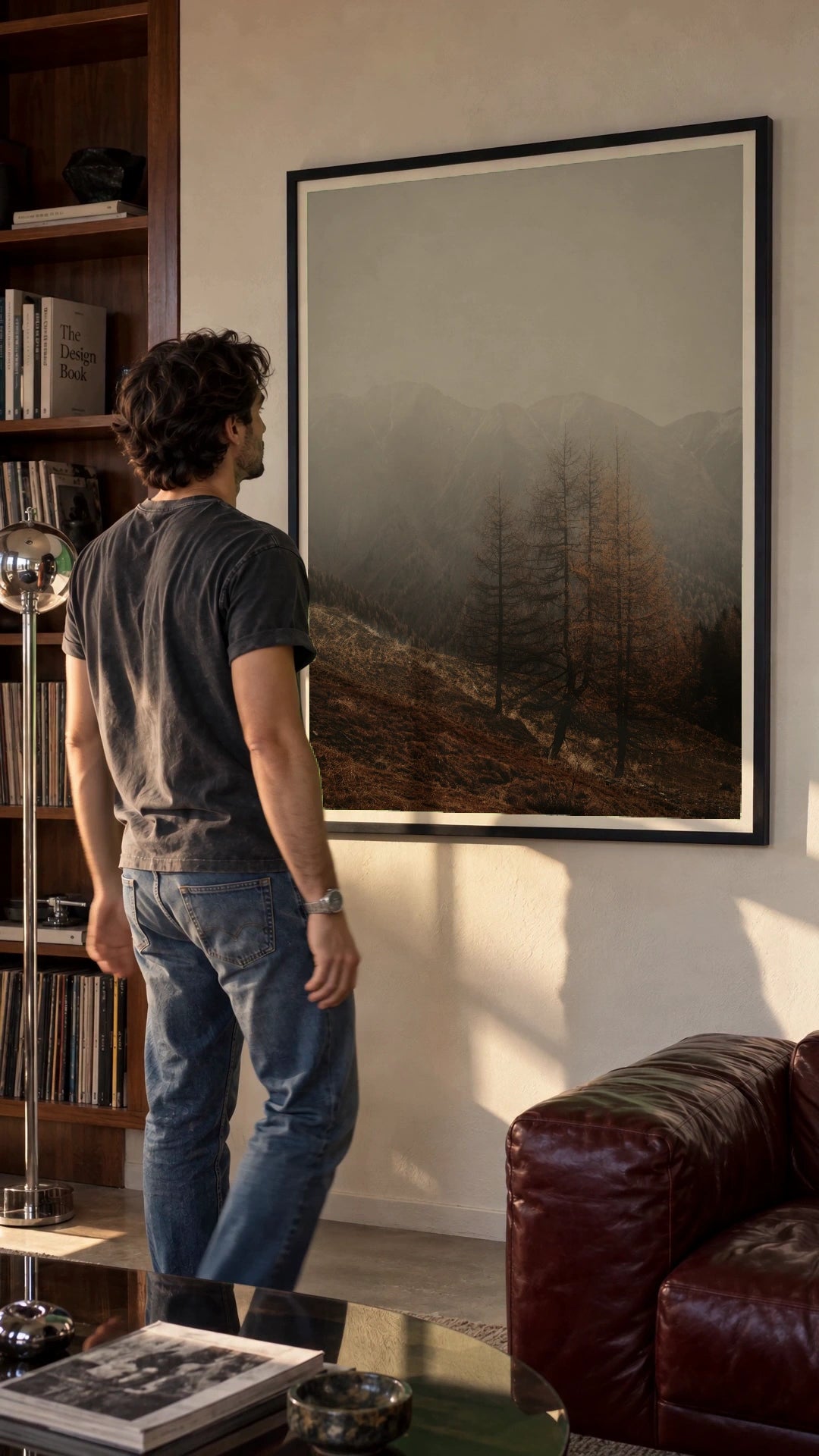 Autumn Mist in a black frame being hung on a wall; styled scene