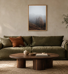 Autumn Mist in a natural wood frame above an olive sofa; styled living-room mockup