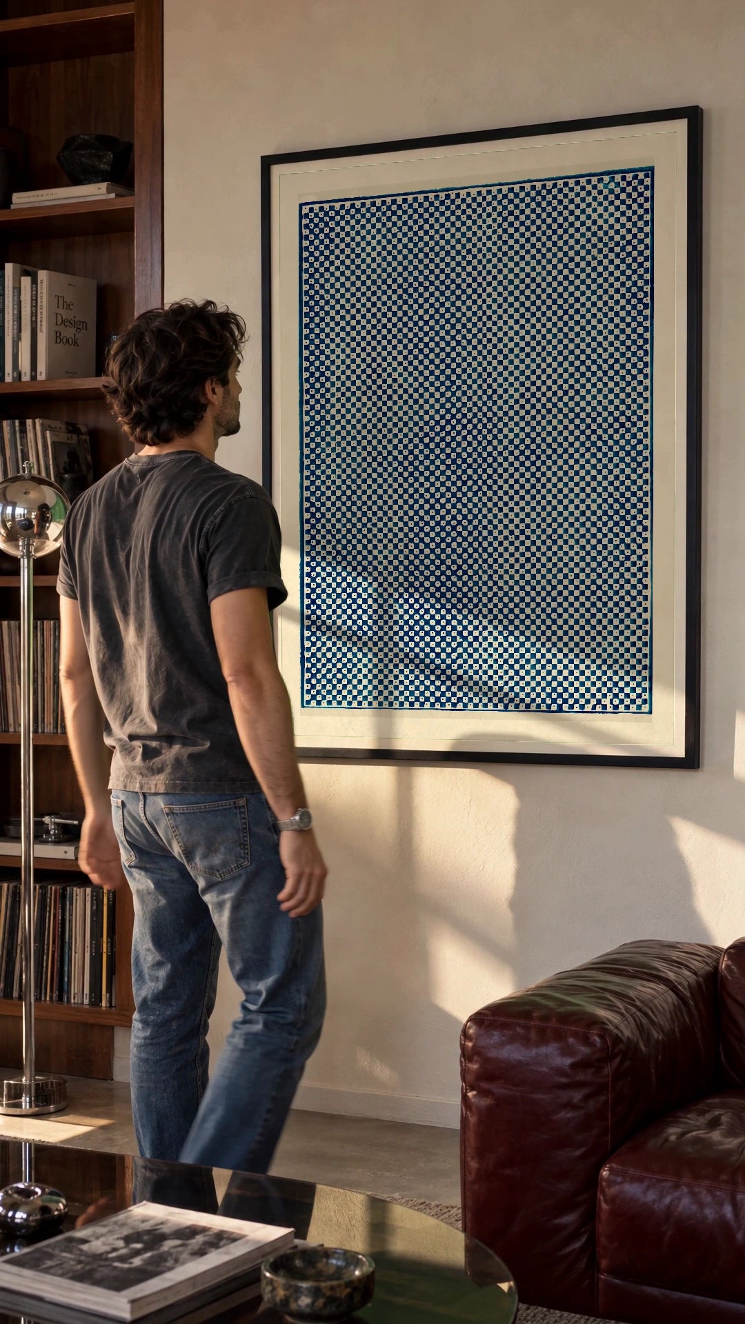 Blue Checkerboard in a black frame being hung on a wall; styled scene