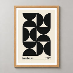 Bauhaus 1919 - Minimalist Geometric Art Print (Black) — realistic natural wood frame studio view