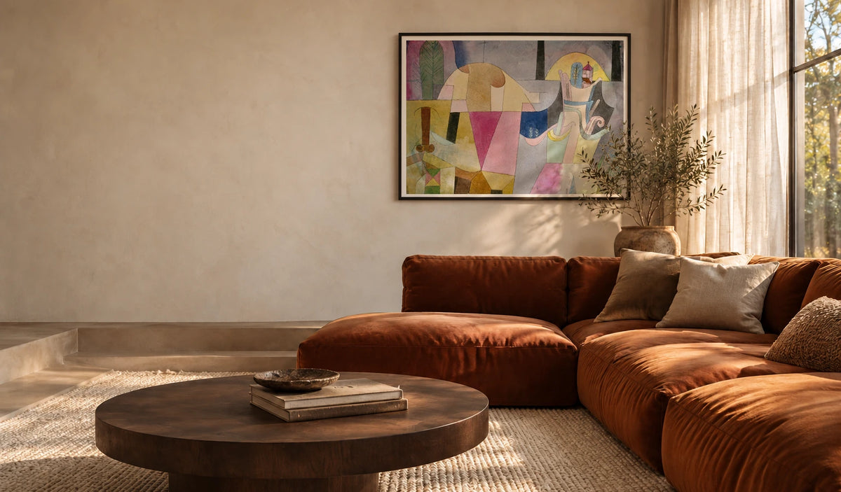 Paul Klee's Black Columns in a Landscape, with an even white border in a black frame above a rust-coloured sofa.