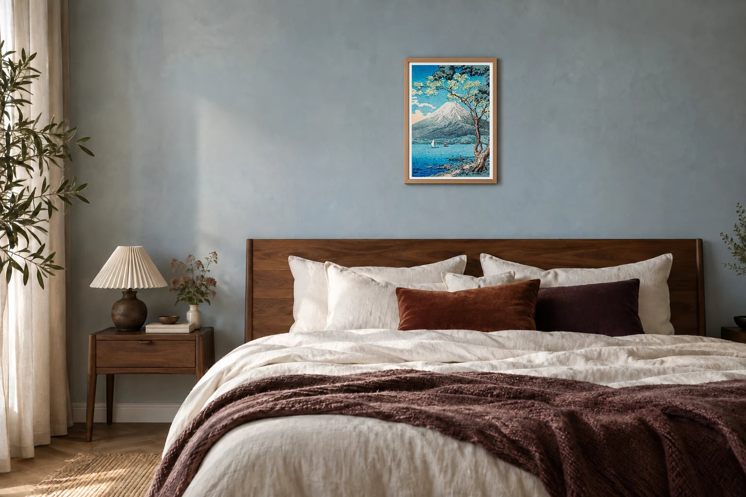 Mount Fuji with blossoms print in a natural timber frame above a walnut bed
