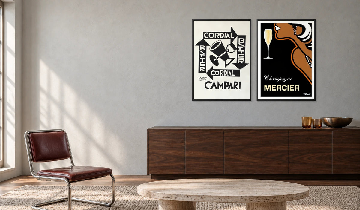 Cordial Bitter Campari and Mercier Champagne prints above a walnut sideboard, with an oxblood chrome chair, travertine coffee table and wool rug.