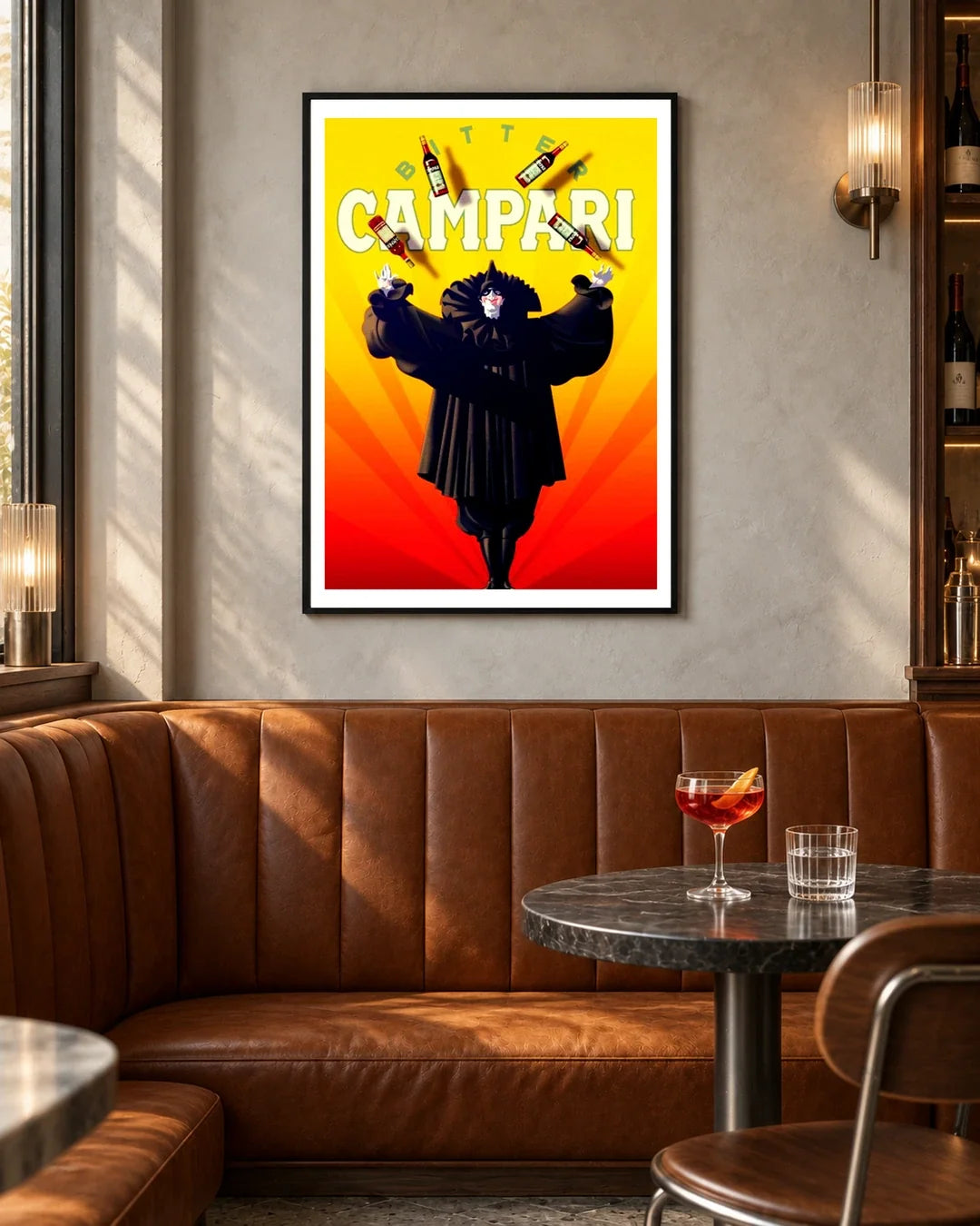 Bitter Campari Magician Poster — black frame in a contemporary bar with grey walls and tan leather seating