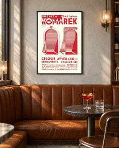 Komarek Italian Advertising Poster by Fortunato Depero — black frame in a contemporary bar with grey walls and tan leather seating