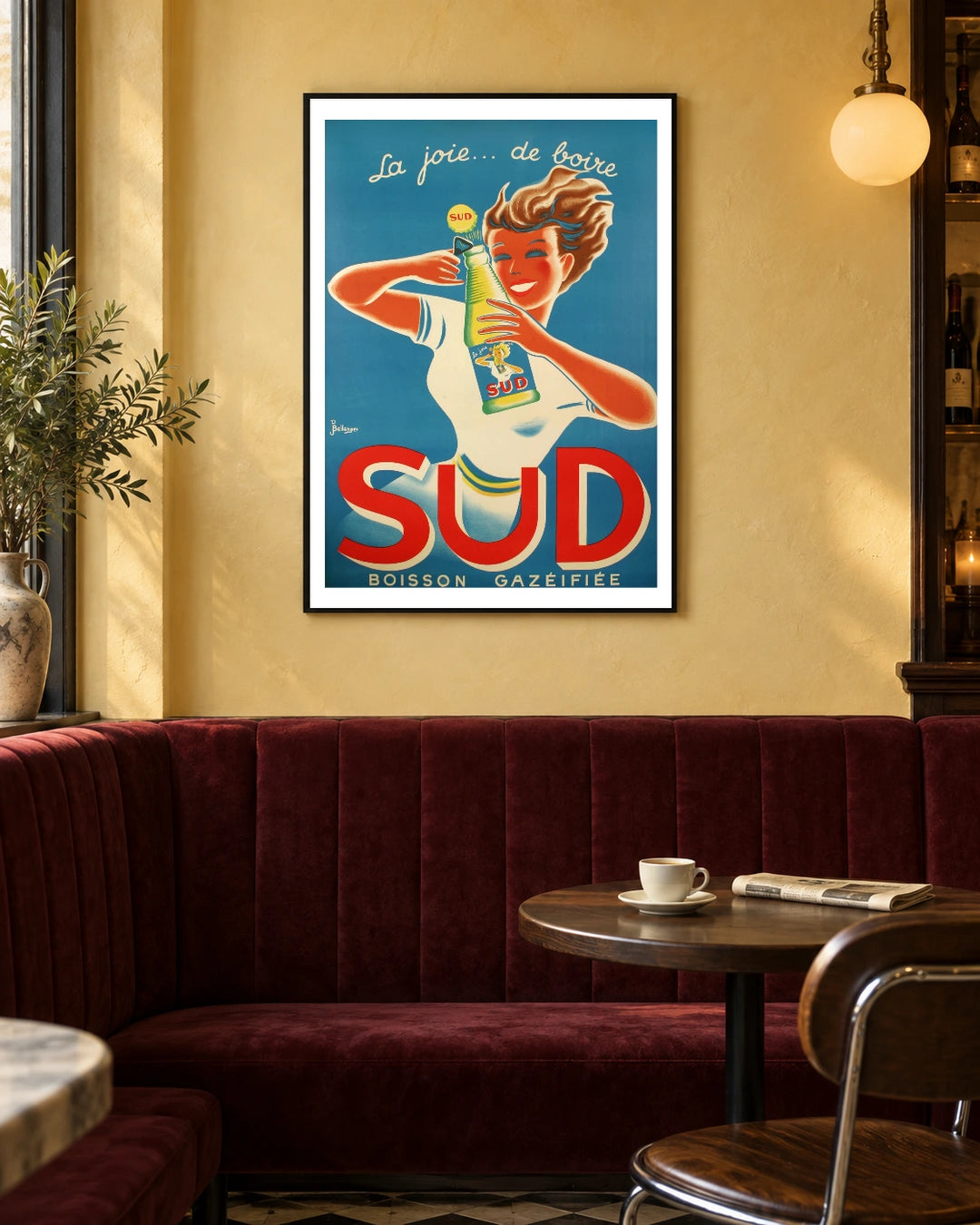 Sud La Joie de Boire Soda Poster — black frame in a warm bistro dining space