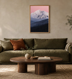Gunsight Mountain at Dusk in a natural wood frame above an olive sofa; styled living-room mockup