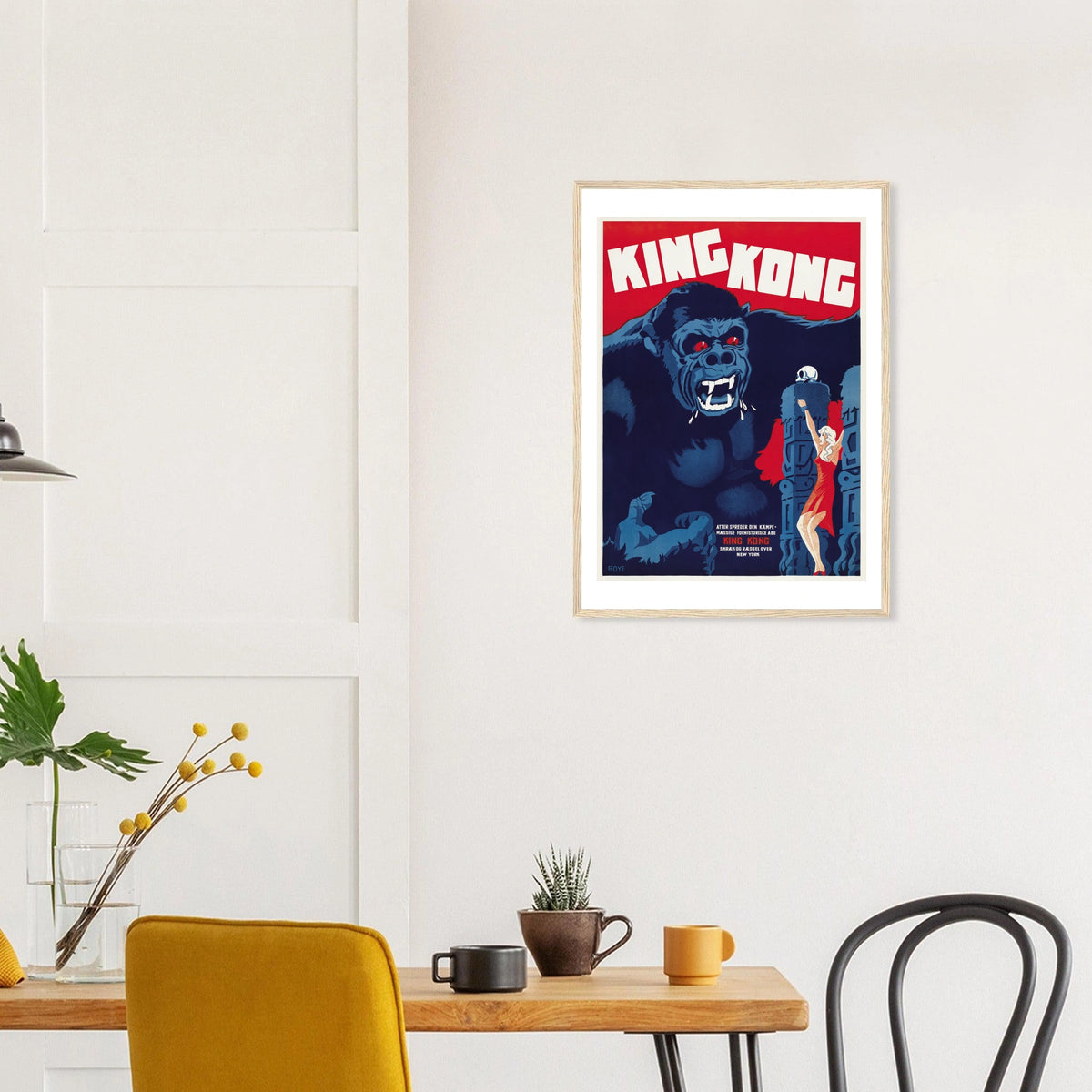 King Kong — Danish Poster in a natural wood frame above a dining table; styled room mockup