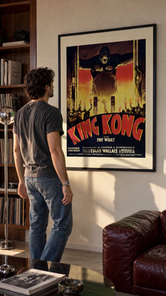 King Kong — French Poster in a black frame being hung on a wall; styled scene