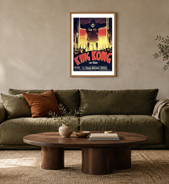 King Kong — French Poster in a natural wood frame above an olive sofa; styled living-room mockup