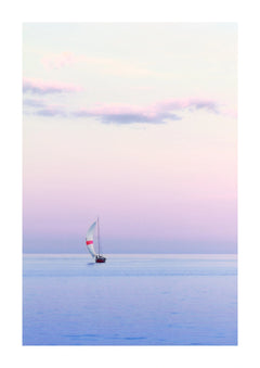 Pastel Sailing Coastal Photographic Print. A small sail moves across a calm sea beneath a pink and lilac sky