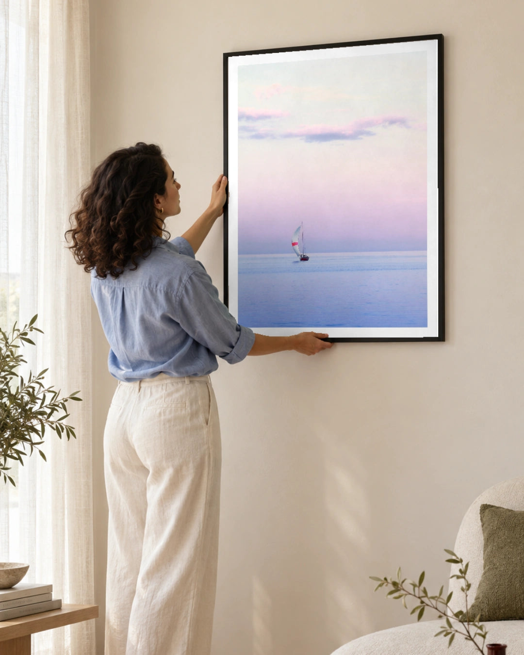 Pastel Sailing Coastal Photographic Print in a black frame; styled woman setting.
