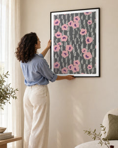 Pink Floral Sidewall Art Print by René Crevel in a black frame; styled woman setting.