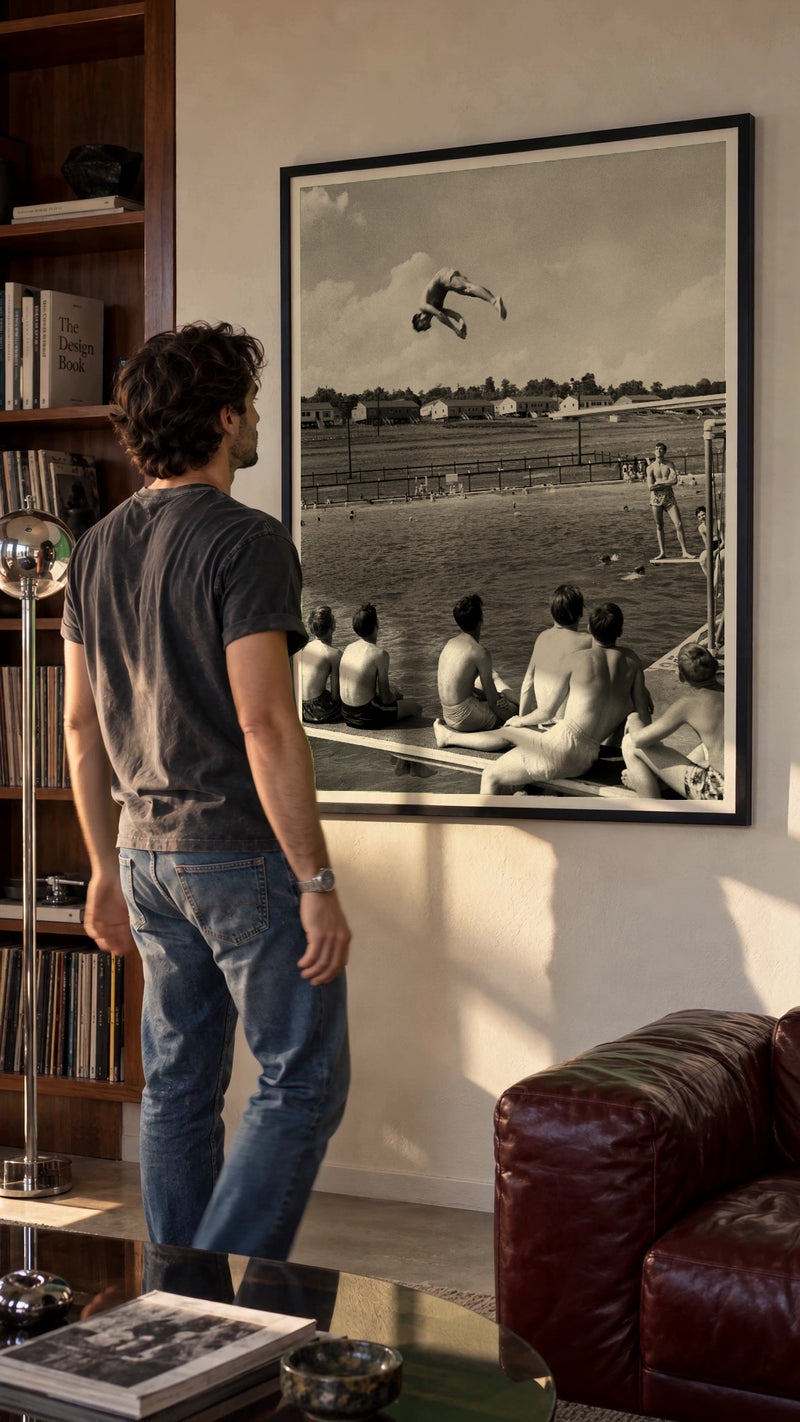 Poolside, 1947 in a black frame being hung on a wall; styled scene