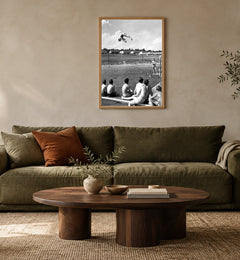 Poolside, 1947 in a natural wood frame above an olive sofa; styled living-room mockup