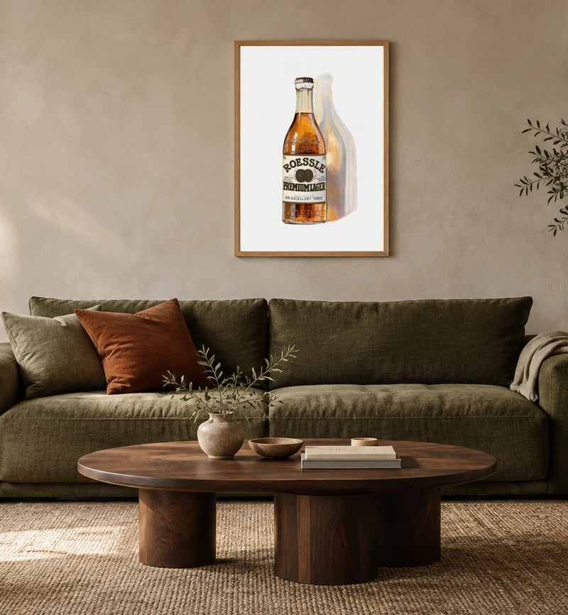 Roessle Premium Lager print in a natural wood frame above an olive sofa; styled room mockup
