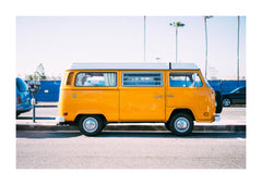 Yellow Van Coastal Photographic Print. A bright yellow van sits beneath a pale sky, with palm trees rising behind it